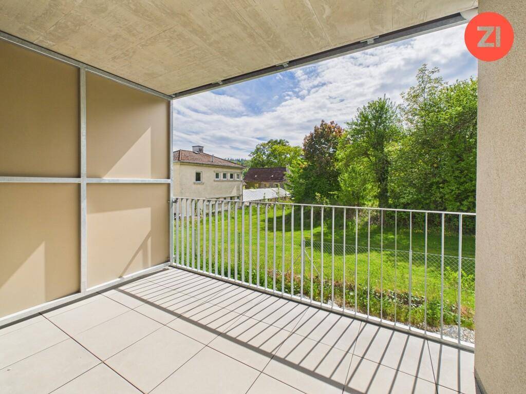 Geräumiger Balkon mit Fliesenboden und weitem Blick ins Grüne.