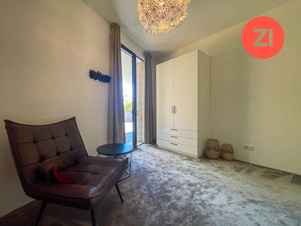 Helles Schlafzimmer mit Zugang zum Außenbereich und einem modernen Kleiderschrank.