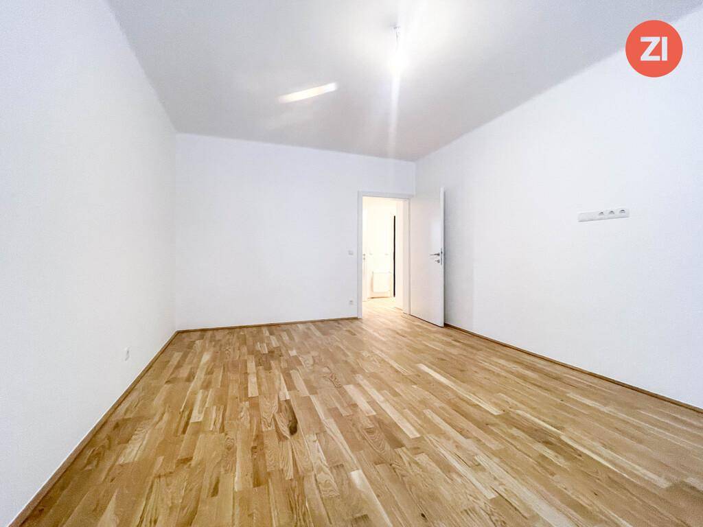 Heller Raum mit Parkettboden und weiß gestrichenen Wänden, ideal als Schlaf- oder Arbeitszimmer.