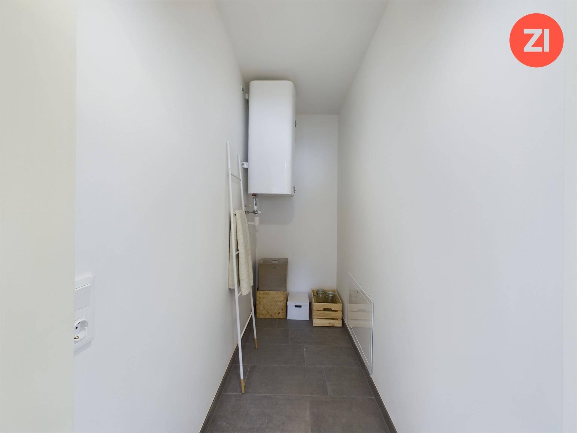 Praktischer Abstellraum mit Warmwasserboiler und Fliesenboden für zusätzlichen Stauraum.