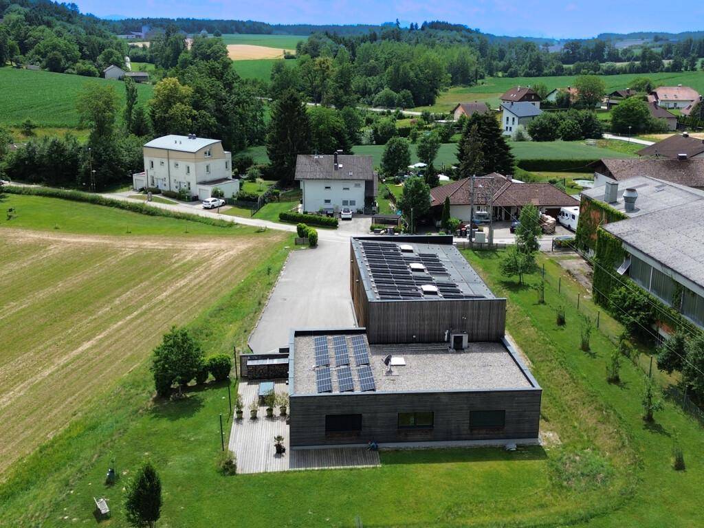 Übersicht aus der Vogelperspektive des modernen Gebäudes mit Solaranlagen und der ländlichen Umgebung.