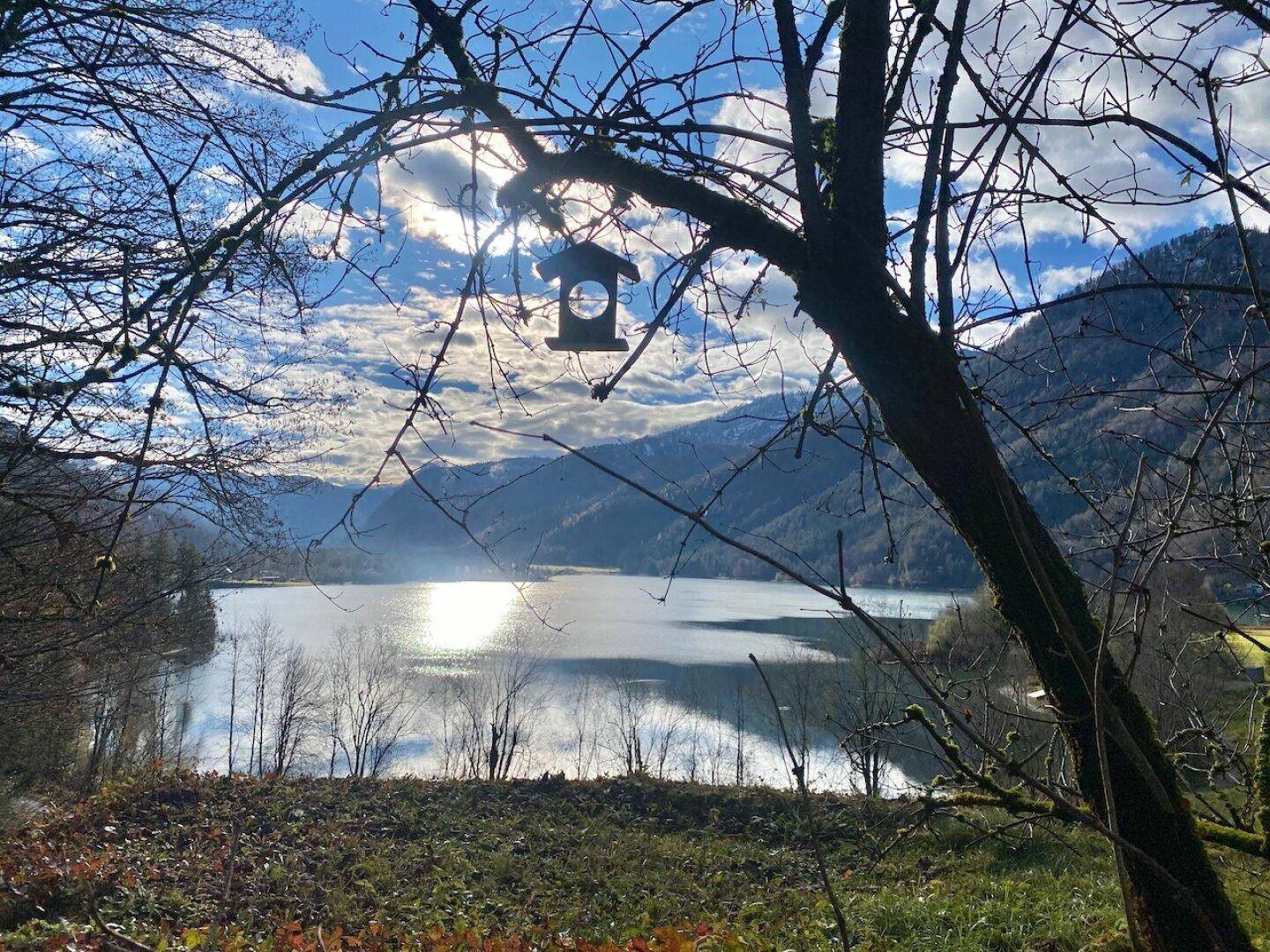 Malerischer Blick auf einen See und die umliegenden Berge an einem sonnigen Tag.