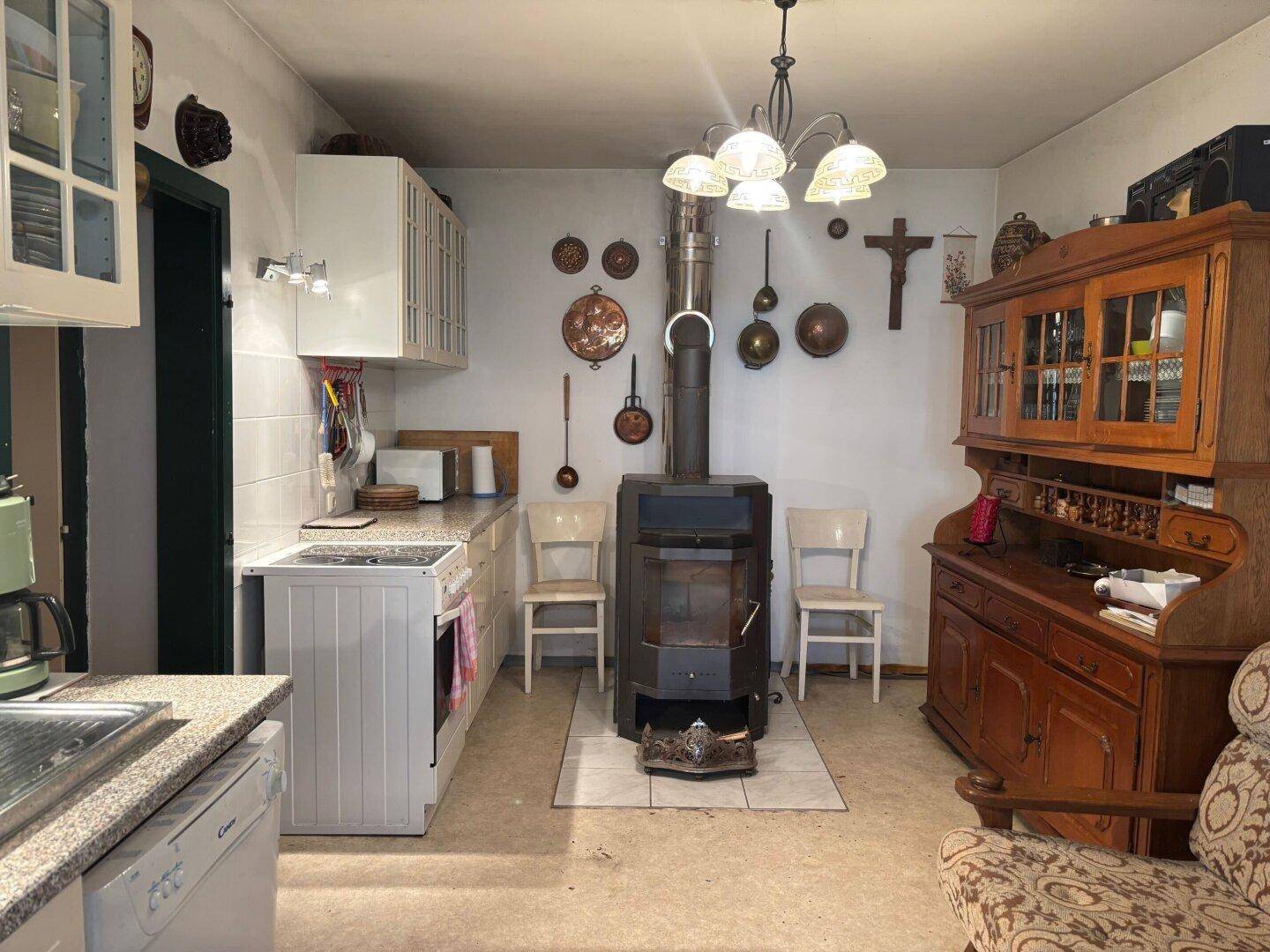 Rustikale Küche mit Holzofen, einfachen Schränken und traditionellen Dekorationen.