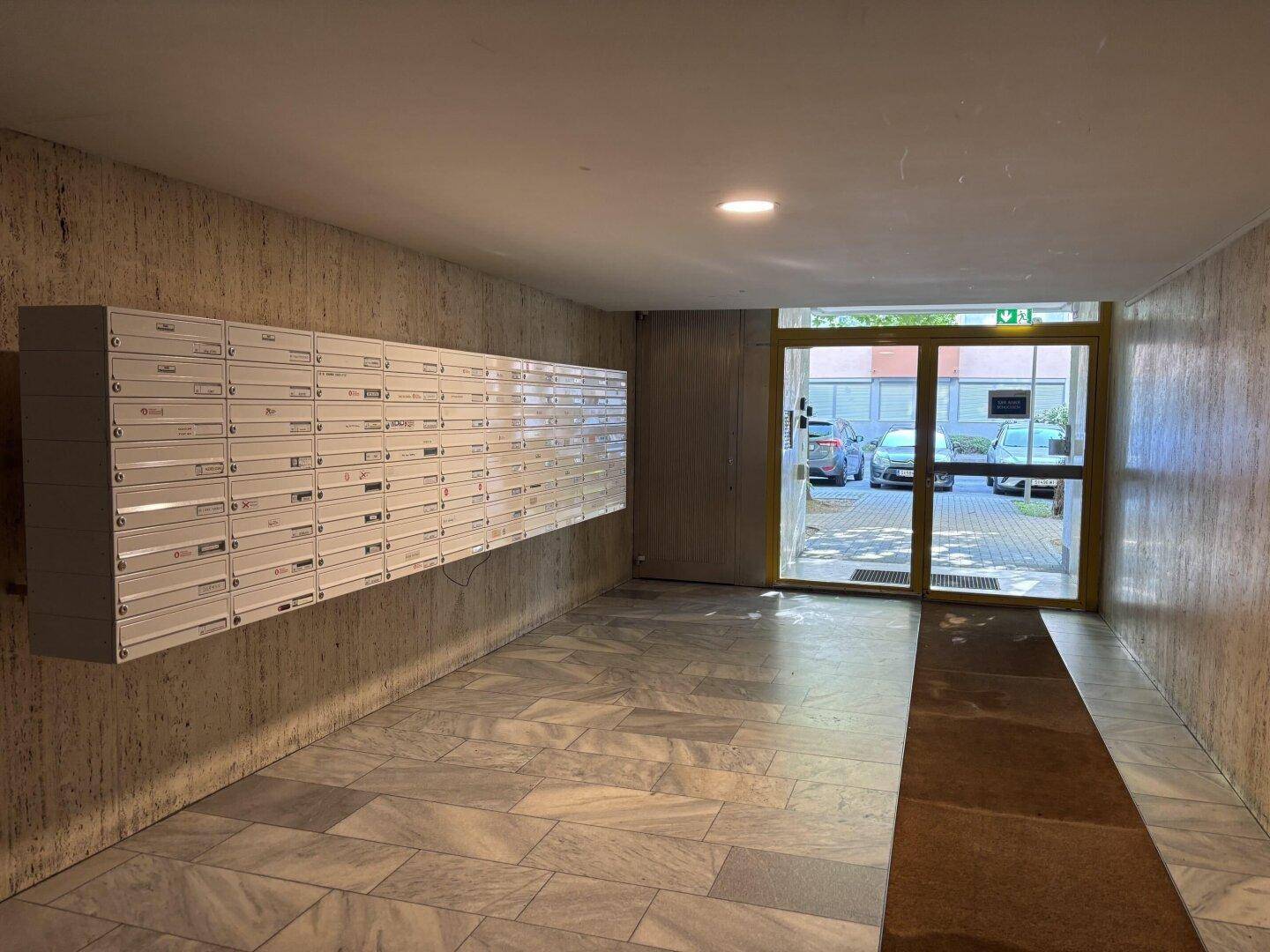 Eingangsbereich des Gebäudes mit Briefkästen und Zugang zum Treppenhaus.