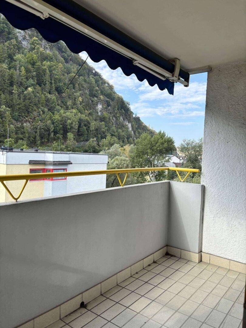 Kleiner Balkon mit Fliesenboden und Blick auf die bewaldeten Hügel.