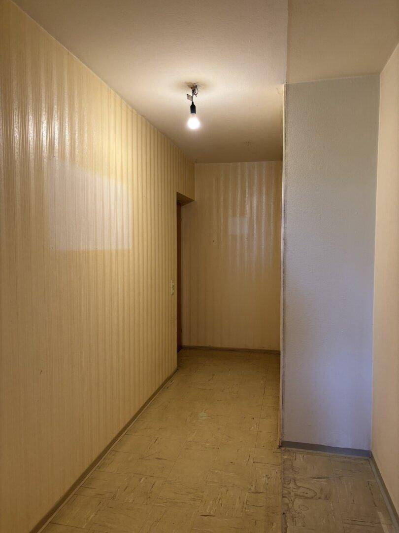 Heller Flur mit gestreifter Tapete und Fliesenboden, verbindet die Wohnbereiche.