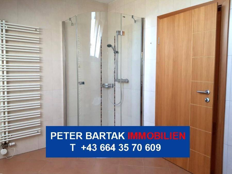 Badezimmer mit Fliesenboden, Duschkabine und beheiztem Handtuchhalter, praktisch und funktional.
