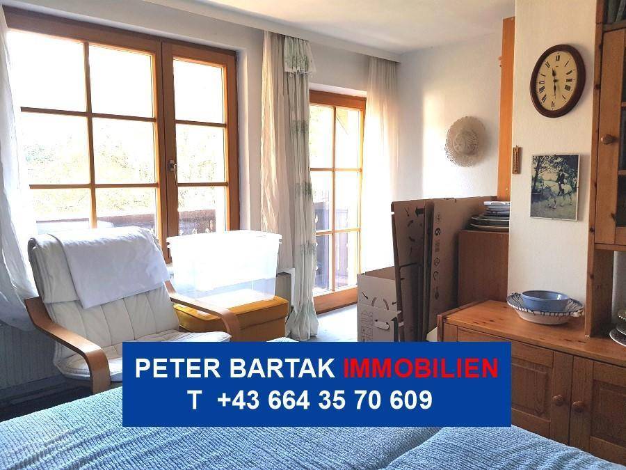 Helles Schlafzimmer mit Zugang zum Balkon und Blick ins Grüne.