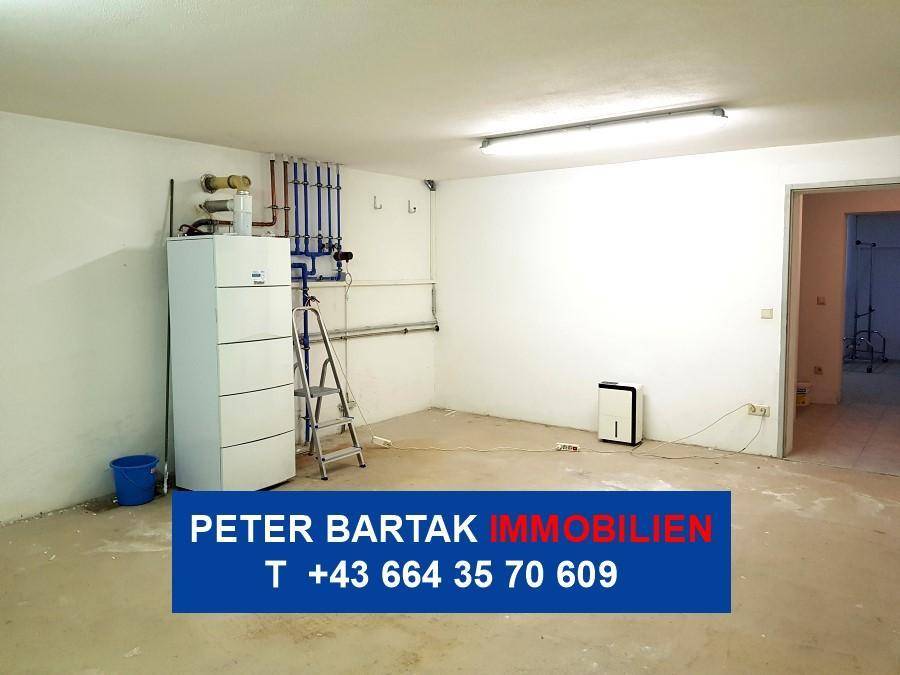 Funktionaler Technikraum im Keller mit Heizungsanlage und weiß gestrichenen Wänden.