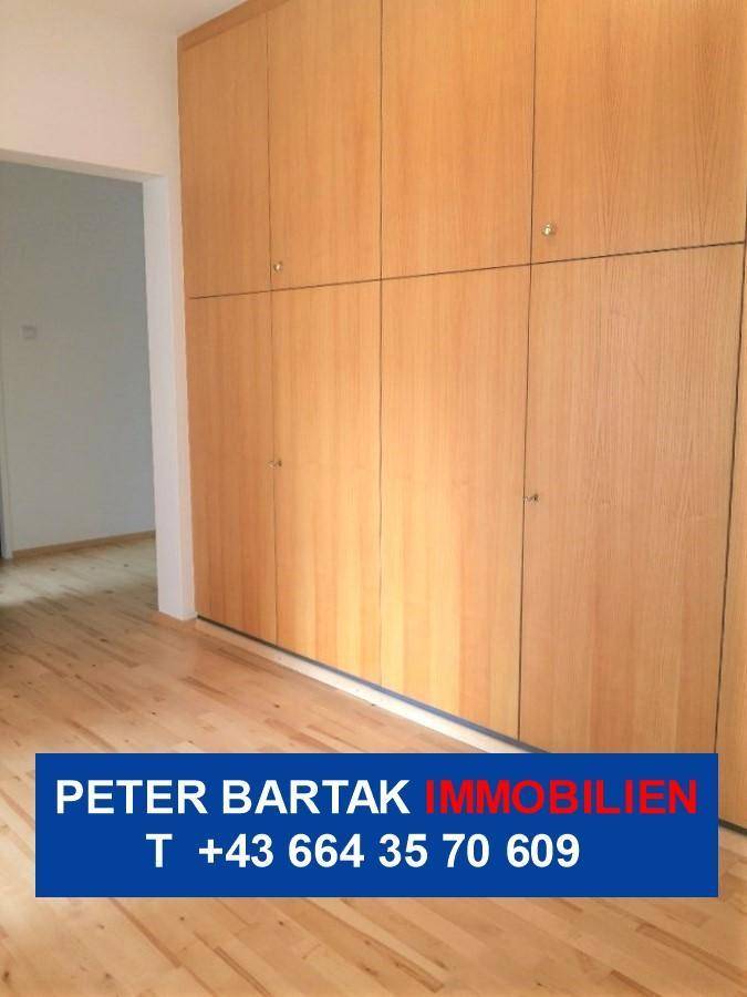 Flur mit praktischen Einbauschränken aus Holz und hellem Parkettboden für viel Stauraum.