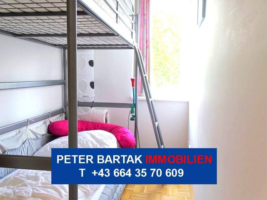 Kinderzimmer mit Etagenbett und einem hellen Fenster, das den Raum gut beleuchtet.