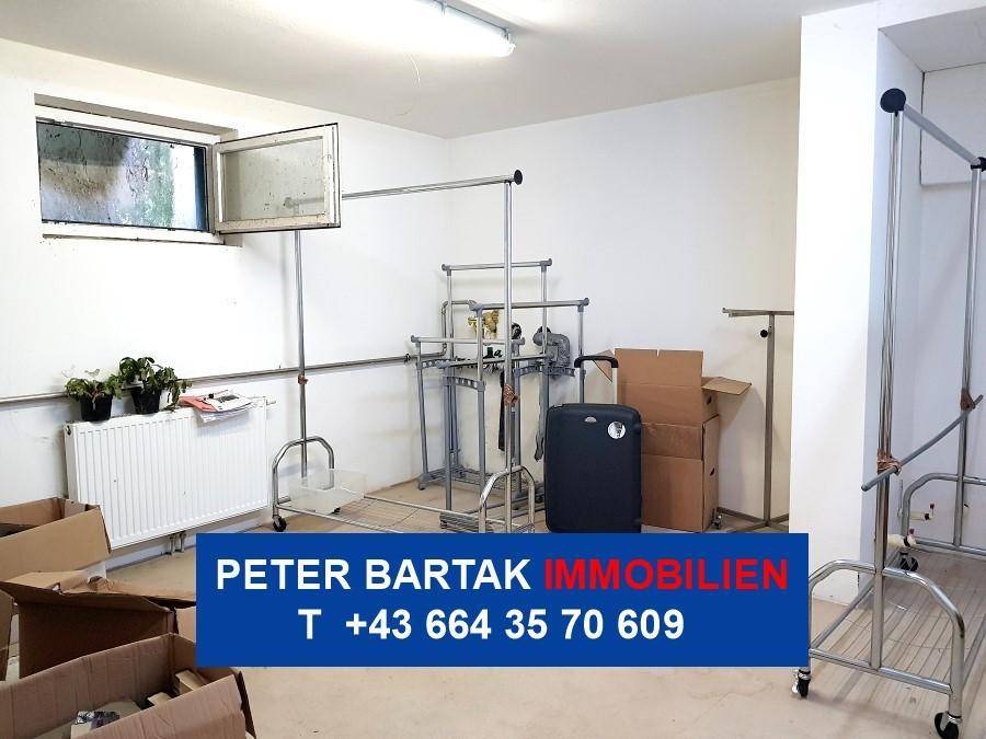 Kellerraum mit kleinem Fenster, Heizkörper und Kleiderständern, vielseitig nutzbar.
