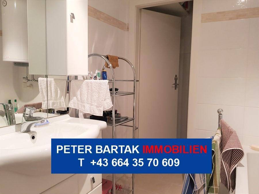 Badezimmer mit Waschbecken, Spiegel und einem praktischen Regal für Badutensilien.