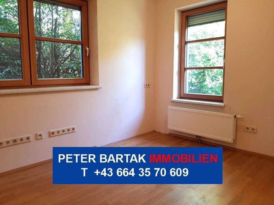 Helles Zimmer mit Parkettboden und zwei Fenstern, ideal als Schlaf- oder Arbeitszimmer nutzbar.