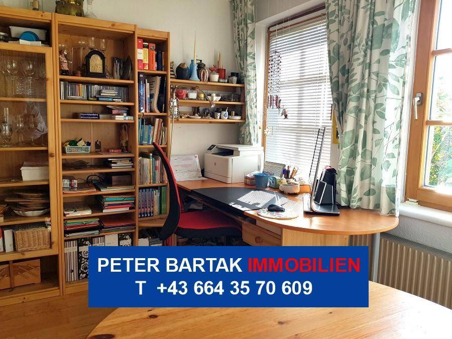 Funktionaler Arbeitsbereich mit Schreibtisch, Büchern und Blick ins Grüne.