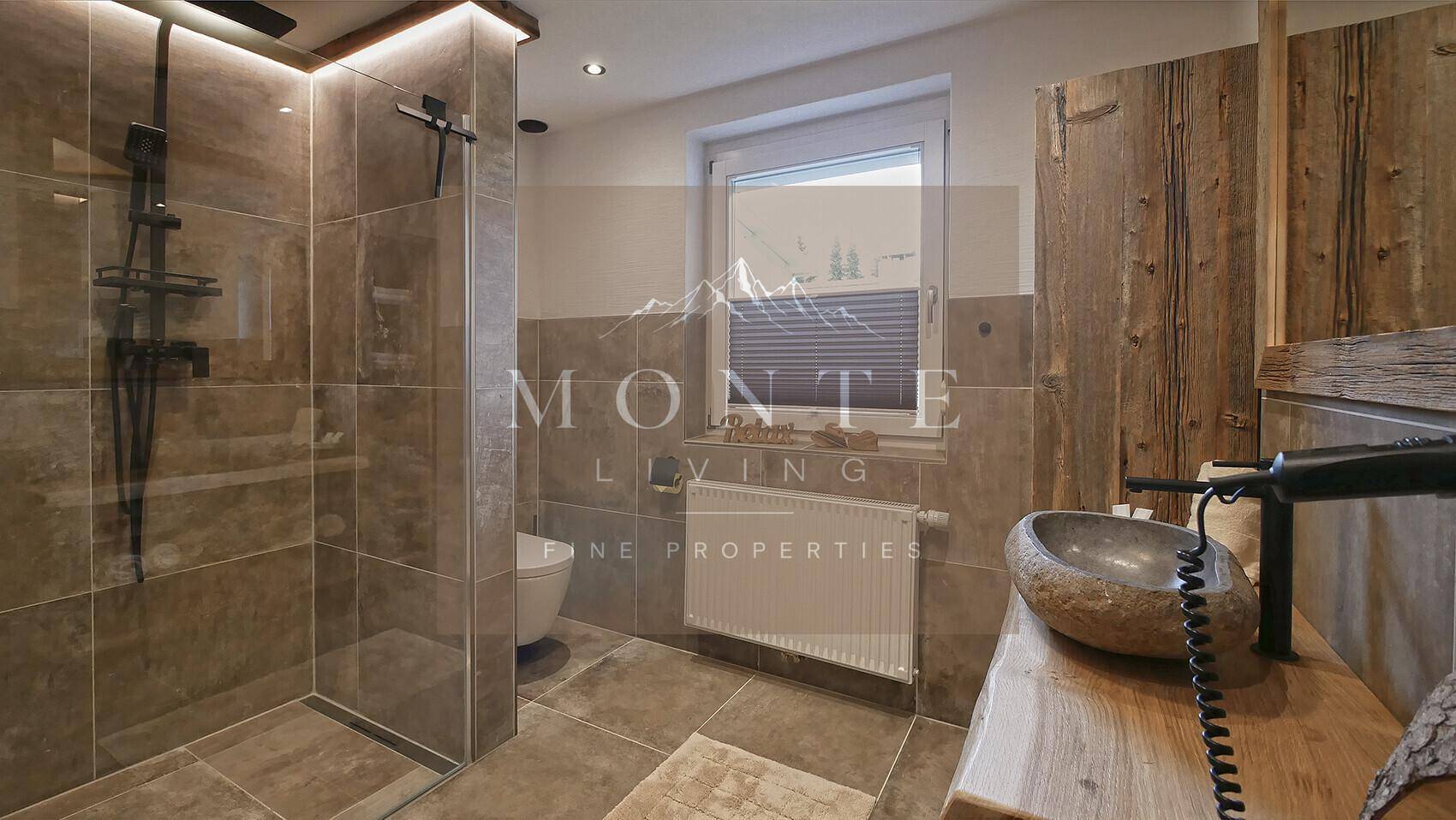 Modernes Badezimmer mit begehbarer Dusche, Natursteinwaschbecken und rustikalen Holzelementen.