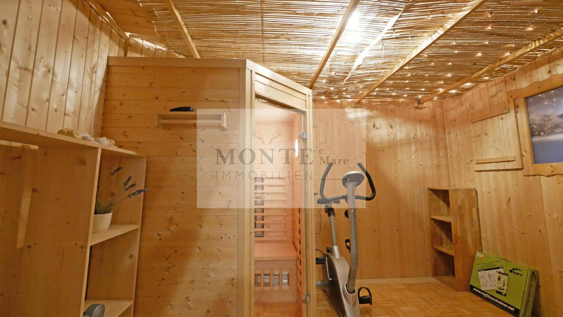 Wellnessbereich mit Sauna und Fitnessgerät, umgeben von Holzverkleidung.
