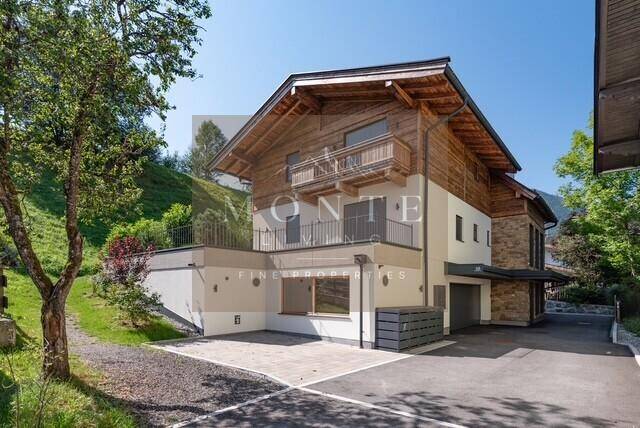 Attraktives Mehrfamilienhaus im alpinen Stil mit Holzfassade und Balkonen.