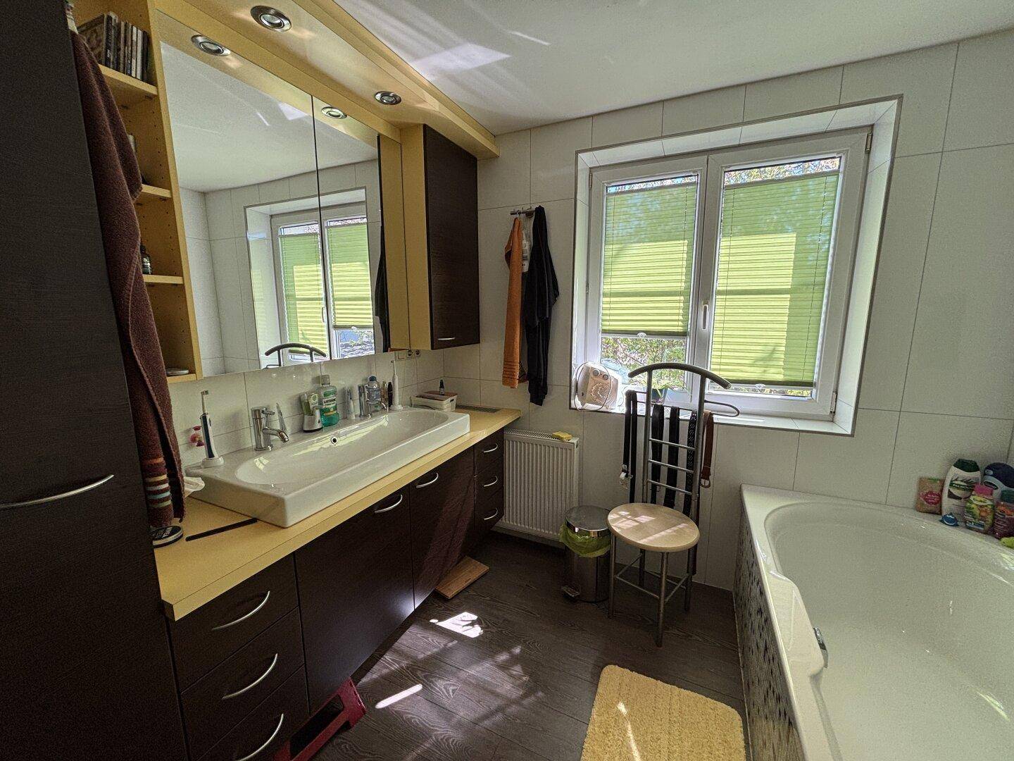 Modernes Badezimmer mit Badewanne, Einzelwaschbecken und Spiegelschrank.