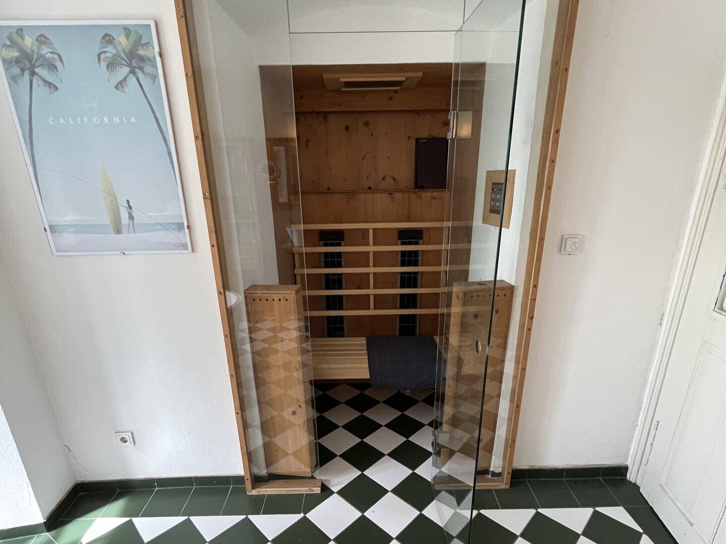 Detailansicht der modernen Sauna mit Holzausstattung und Glastür im Badezimmer.