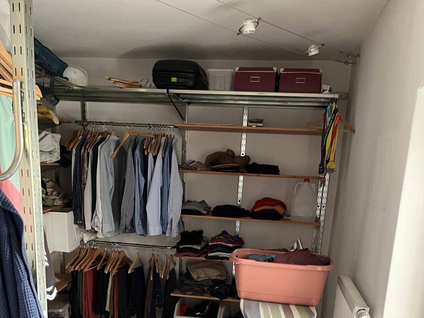 Praktischer begehbarer Kleiderschrank mit offenen Regalen und viel Stauraum für Kleidung.