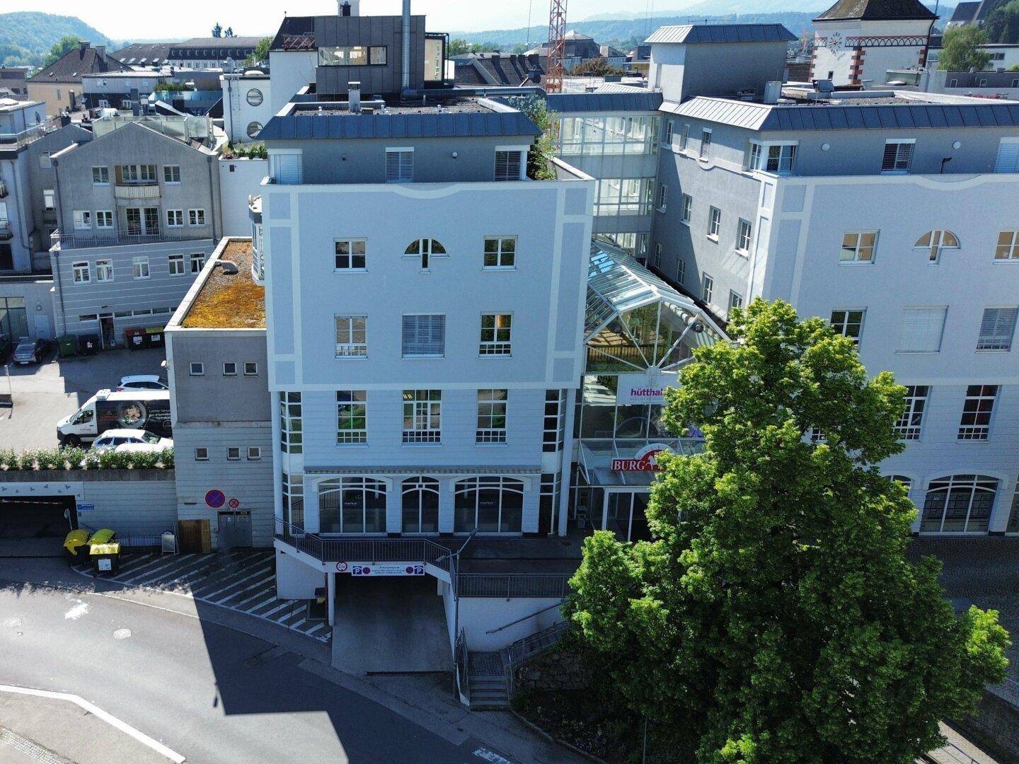Ansicht des modernen Gebäudes mit Glasfassade und begrüntem Dach in städtischer Umgebung.
