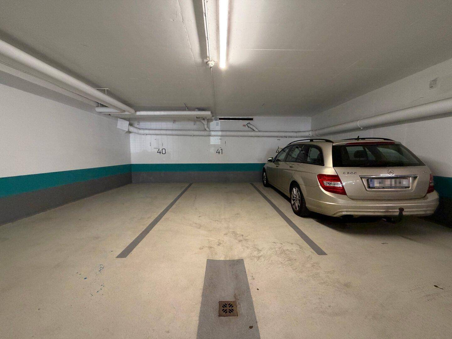 Stellplatz in der Tiefgarage mit einem geparkten Auto und klarer Markierung auf dem Boden.