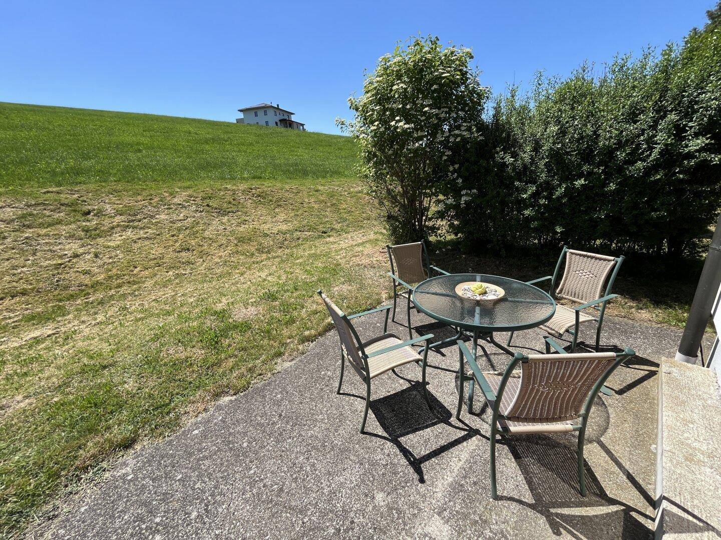 Gemütliche Terrasse mit Gartenmöbeln und weitem Blick auf die umliegende Natur.