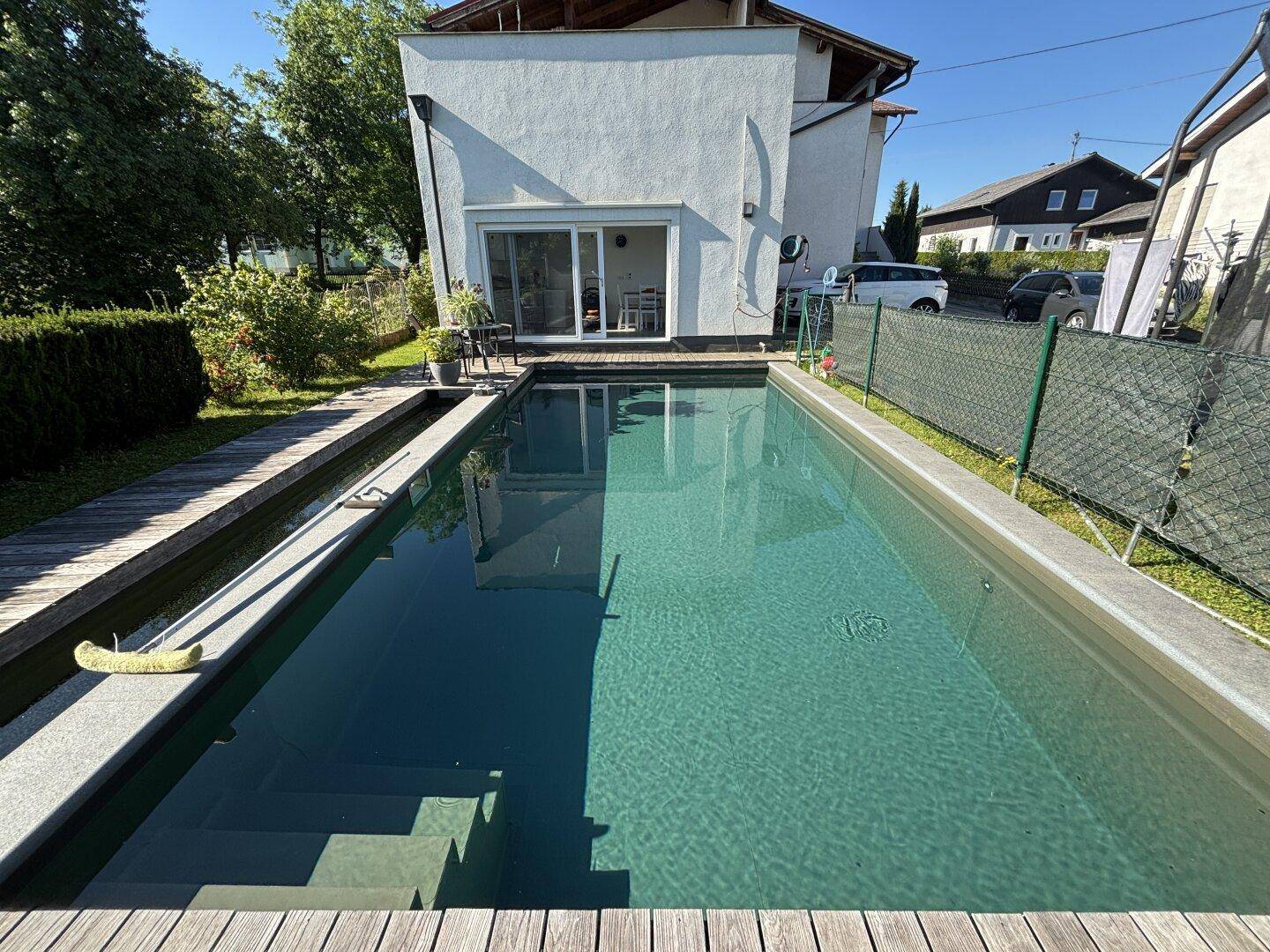 Hinteransicht des Hauses mit direktem Zugang zum erfrischenden Pool und dem sonnigen Gartenbereich.