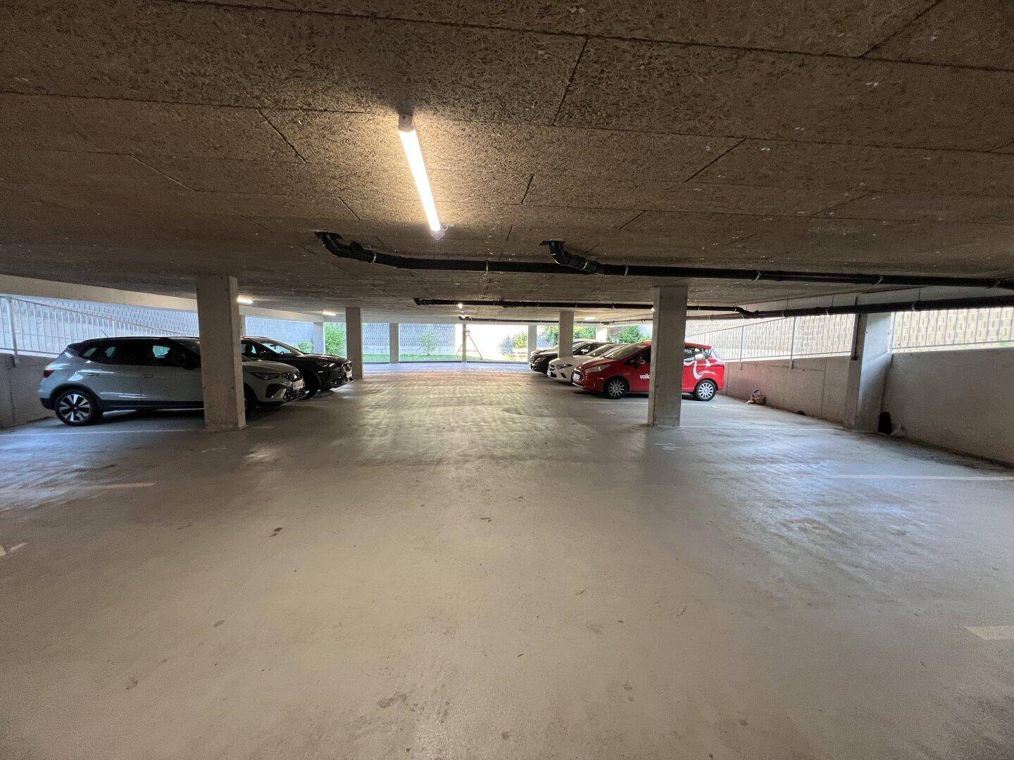 Geräumige Tiefgarage mit mehreren Stellplätzen und Betonwänden.