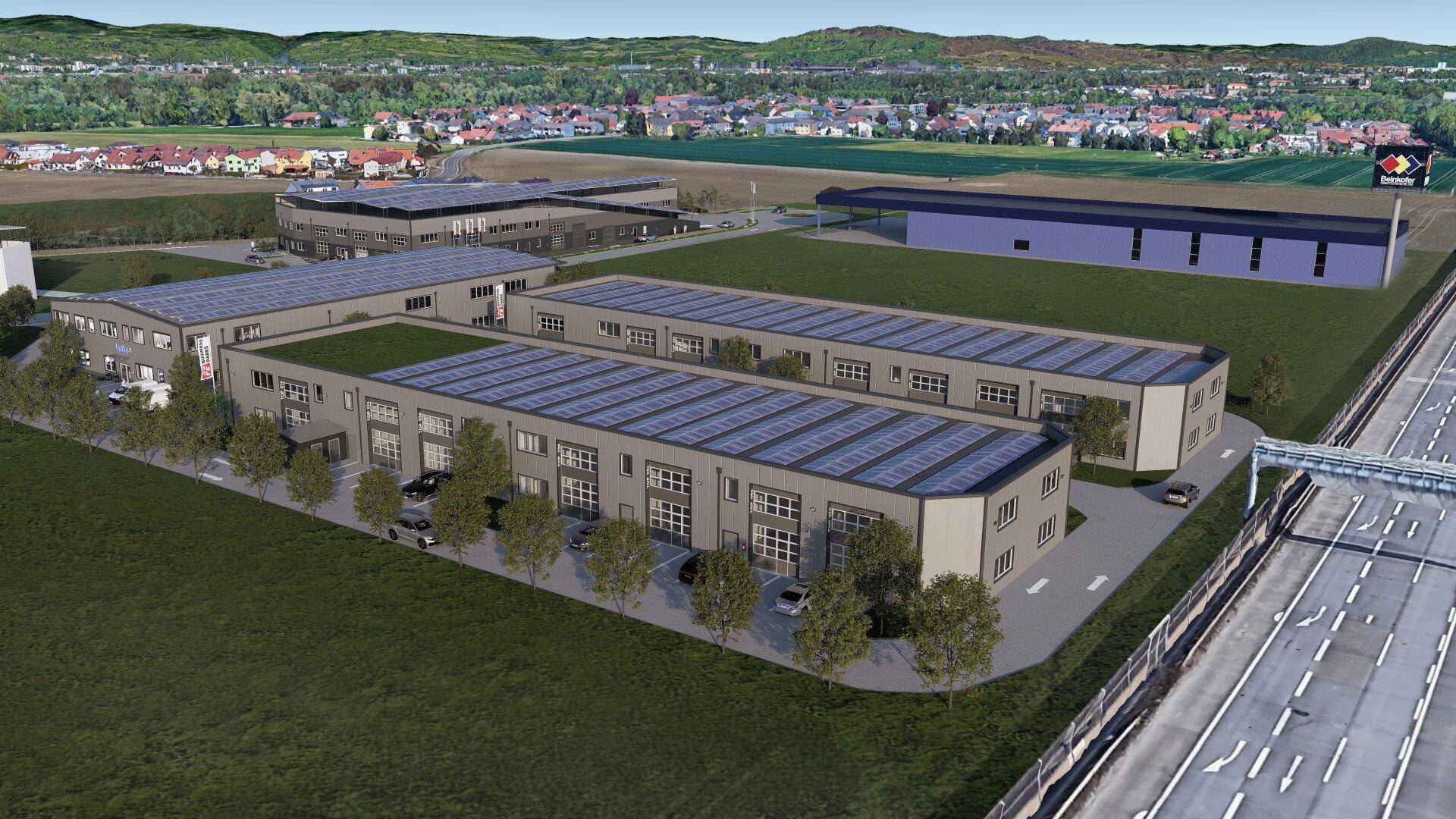 Luftaufnahme eines Gewerbeparks mit mehreren Gebäuden, Solaranlagen und umliegender Landschaft.