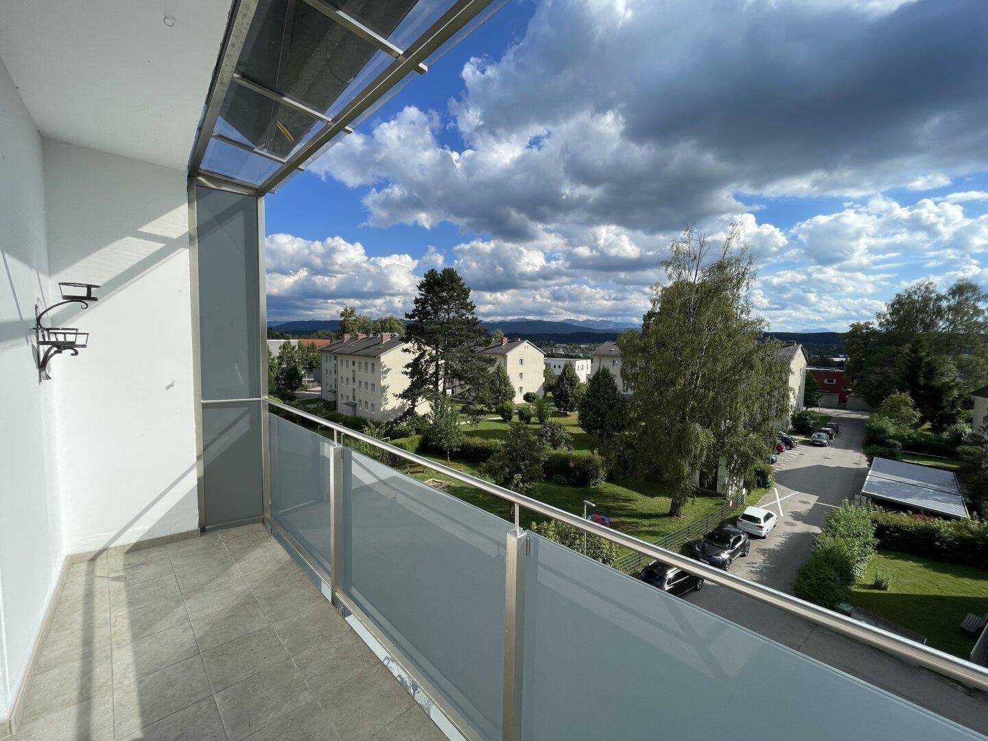 Geräumiger Balkon mit Glasgeländer und weitem Blick über die Umgebung.