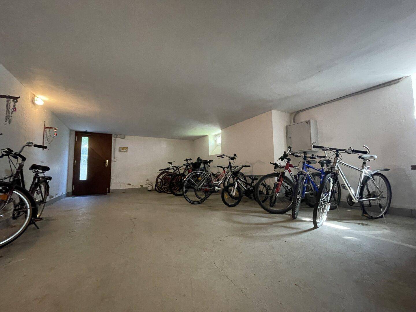 Gemeinschaftlicher Fahrradraum im Keller mit mehreren abgestellten Fahrrädern.