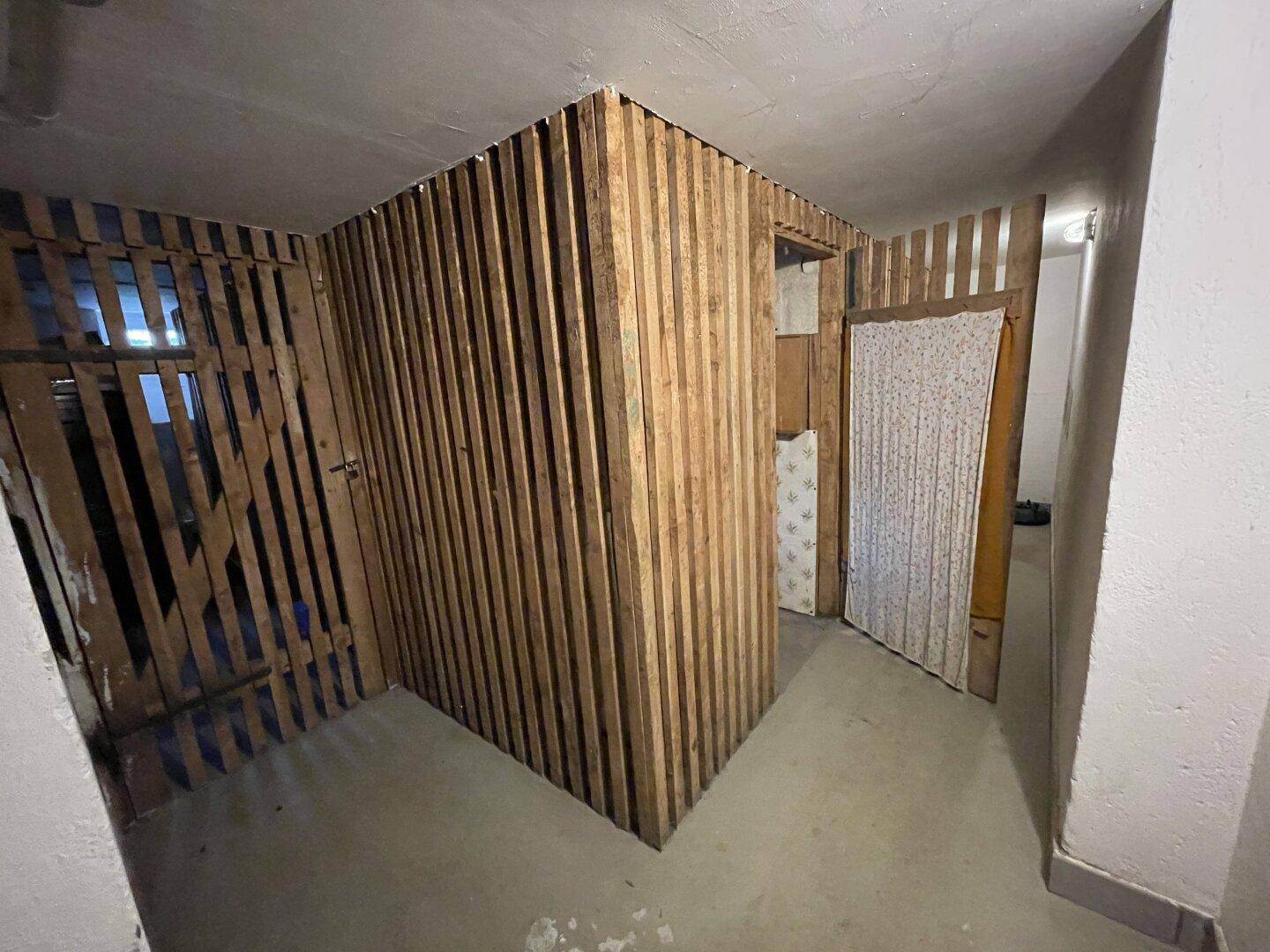Abstellraum im Rohbau mit Holzlatten und begrenzter Sichtbarkeit.
