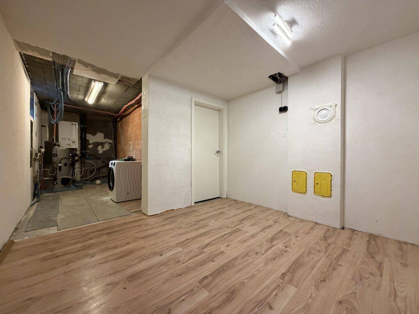 Hauswirtschaftsraum im Keller mit Waschmaschine und Heizungsanlage.