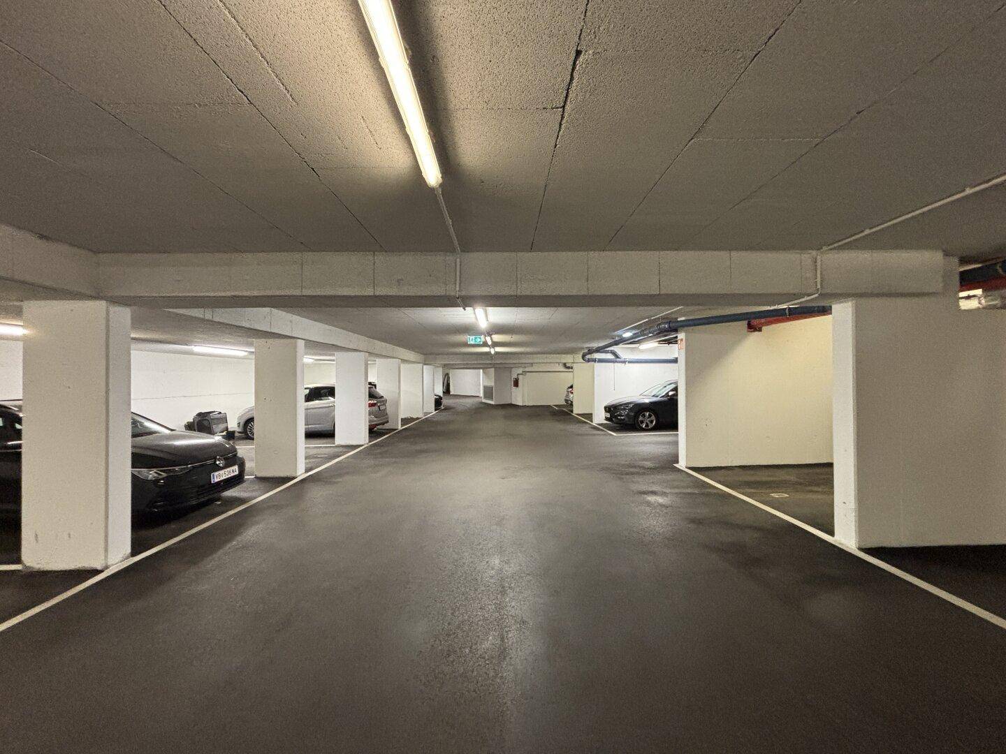 Tiefgarage mit mehreren Stellplätzen und guter Beleuchtung, bietet sicheren Parkraum.