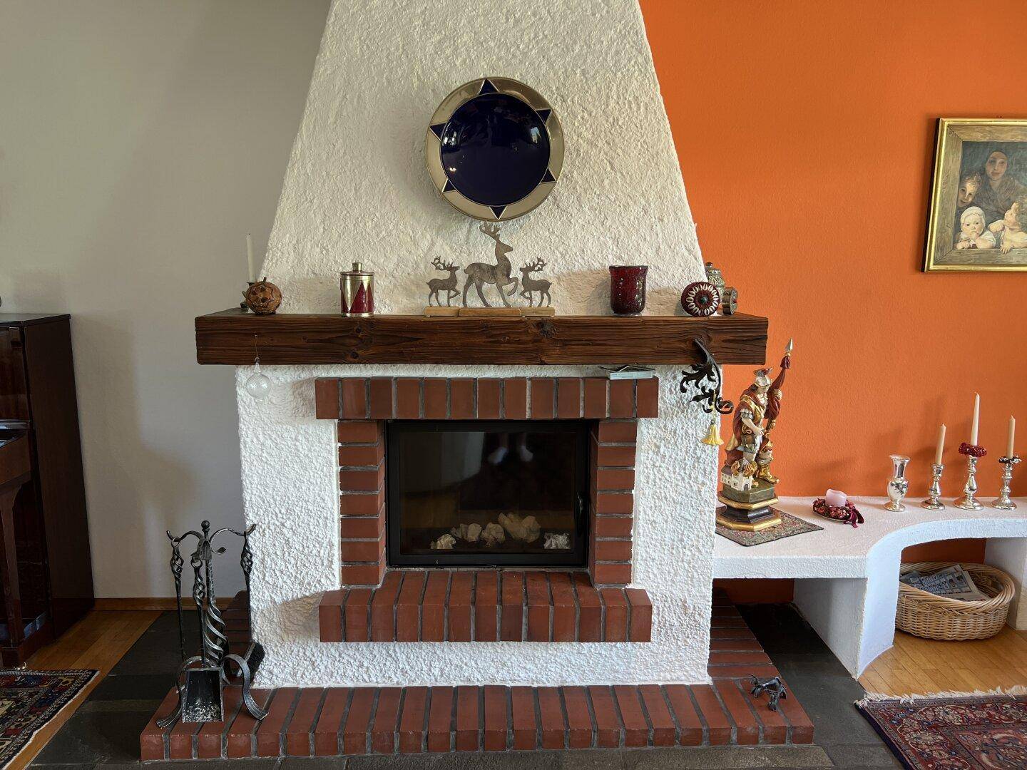 Detailansicht des Kamins im Wohnzimmer, umgeben von traditioneller Dekoration.