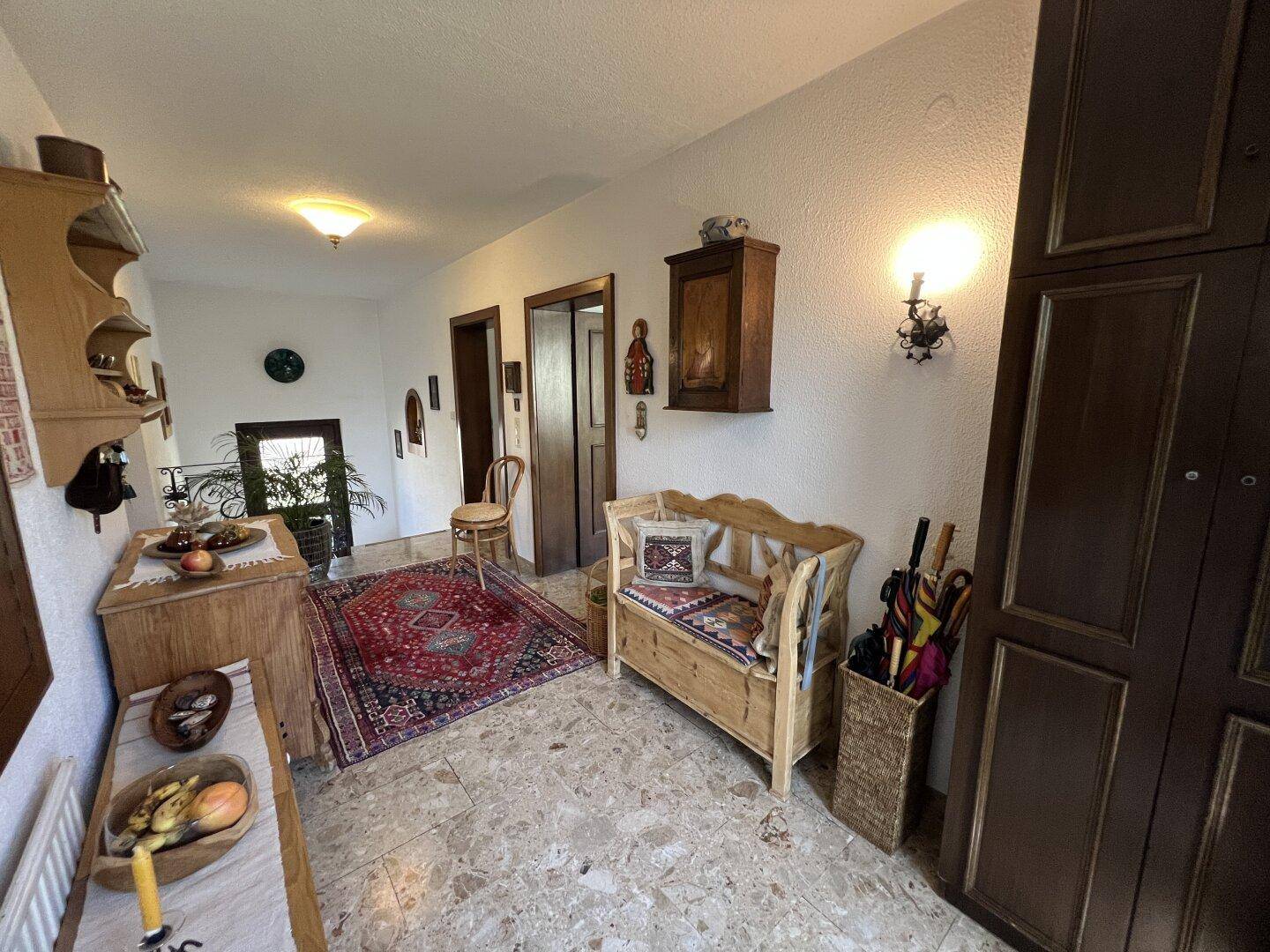 Heller Flur mit traditionellen Holzmöbeln und praktischen Aufbewahrungslösungen.