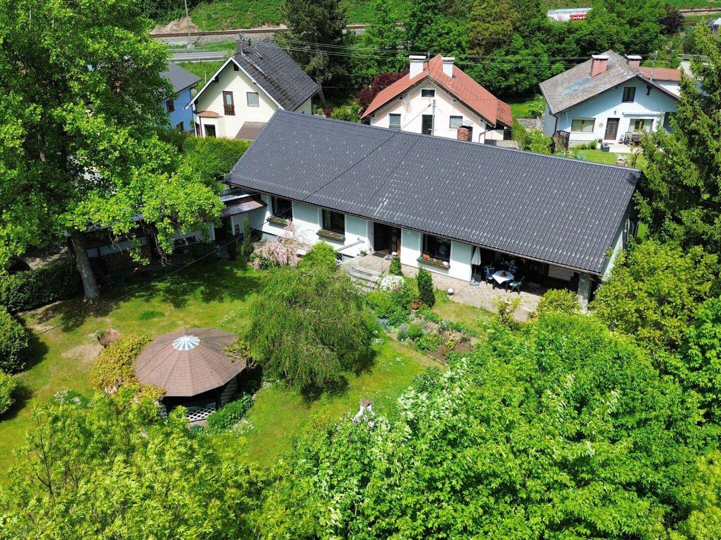 Vogelperspektive eines Hauses mit großem, gepflegten Garten und einem Gartenpavillon.