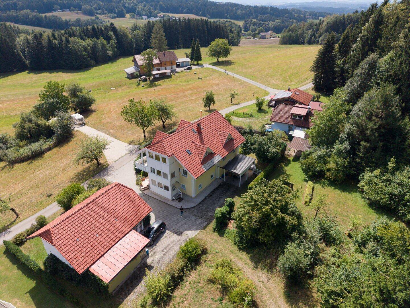 Luftaufnahme des Anwesens mit mehreren Gebäuden und weitläufiger Grünfläche.