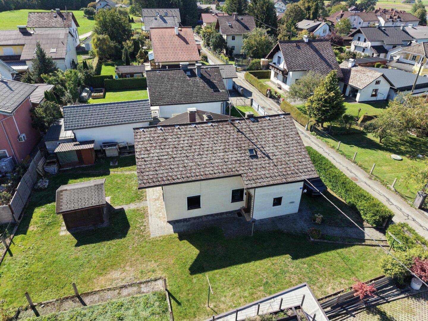 Dachansicht des Hauses mit Garten, Schuppen und Blick auf die umliegende Wohnbebauung.