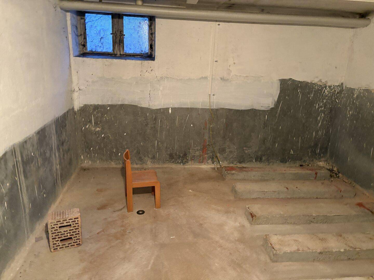 Unausgebauter Kellerraum mit Betonwänden und einem kleinen Fenster, ideal als Lagerfläche.