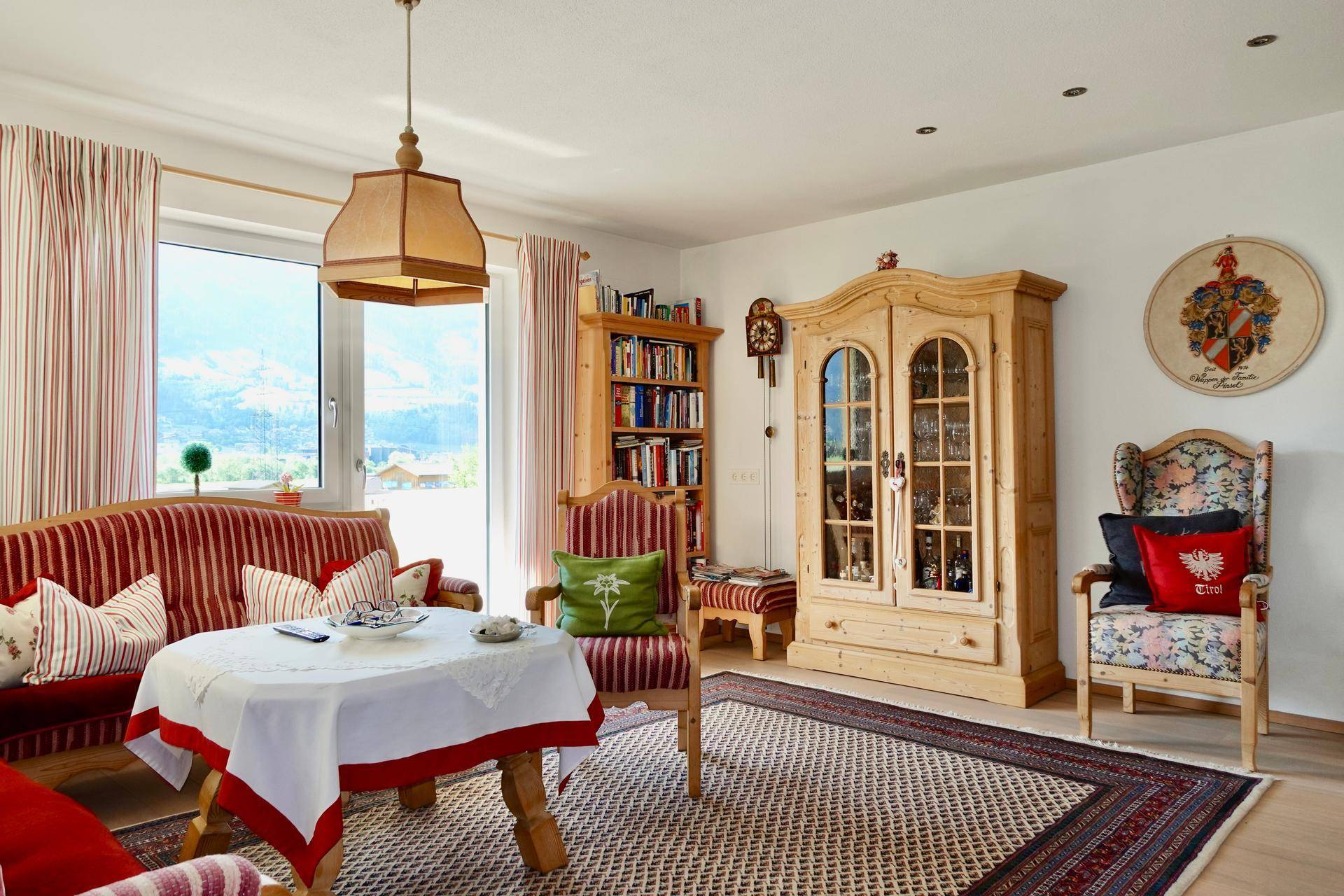 Gemütliches Wohnzimmer im alpinen Stil mit Holzmöbeln und Bergblick.