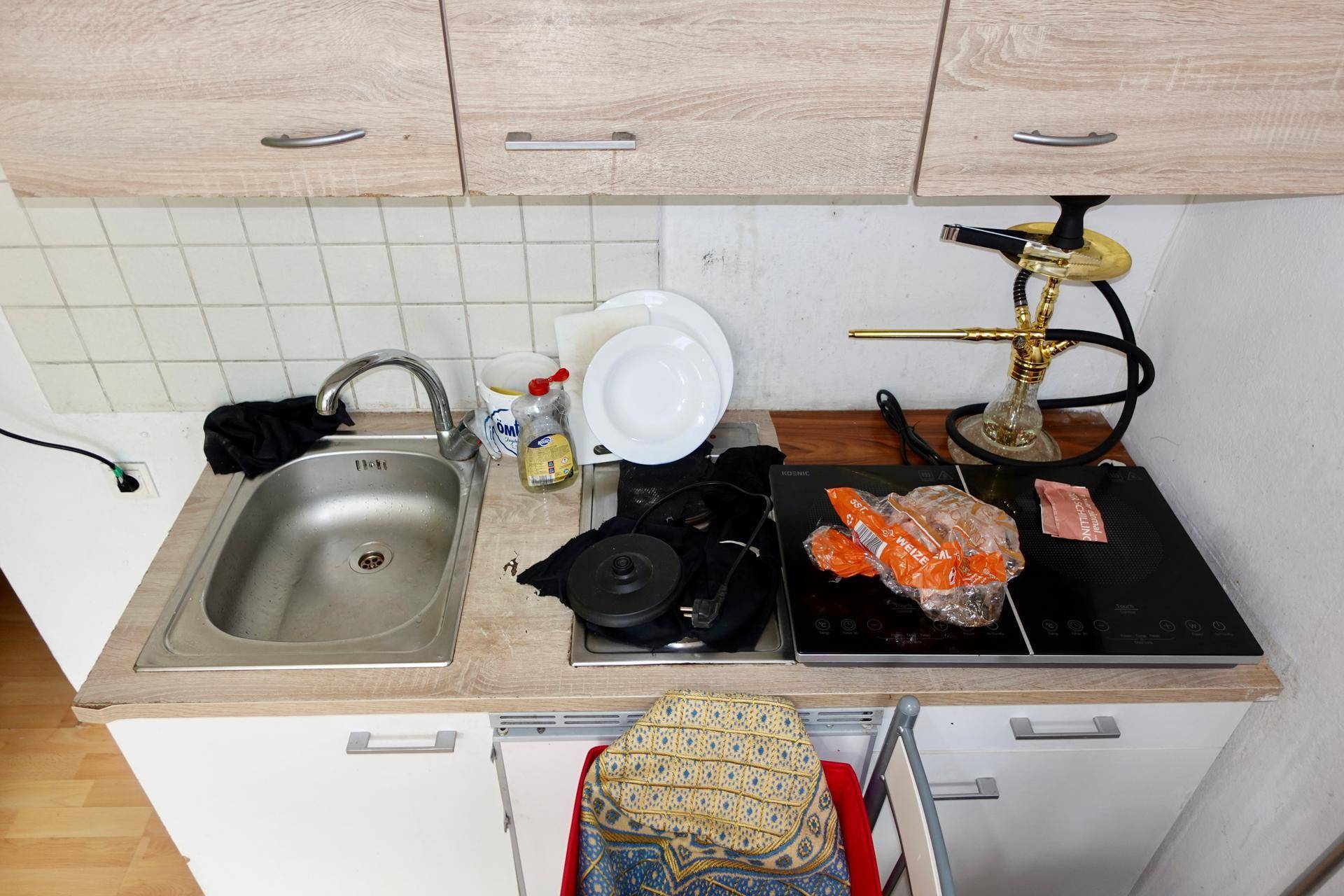 Kleine Küchenzeile mit Spüle, Induktionskochfeld und Holzoptik-Schränken in funktionalem Design.