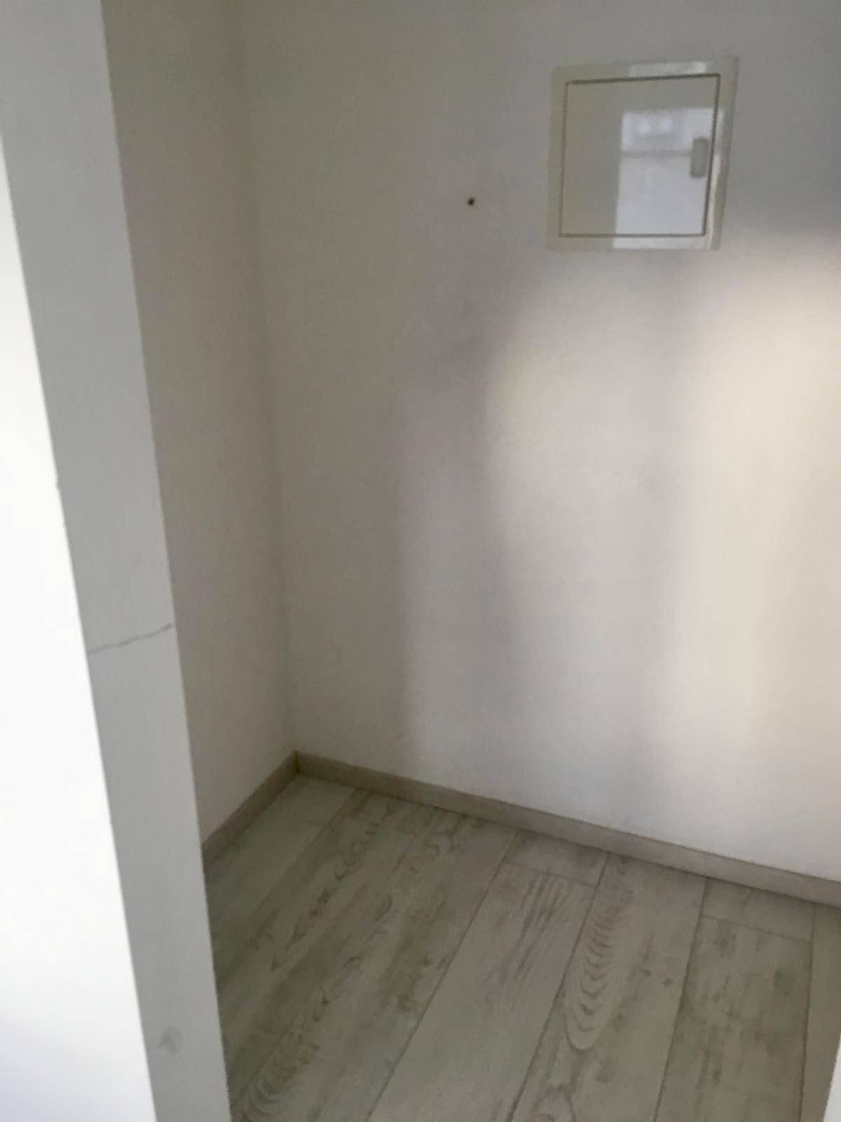 Kleiner, leerer Raum mit hellen Wänden und Laminatboden, ideal als Abstellraum.