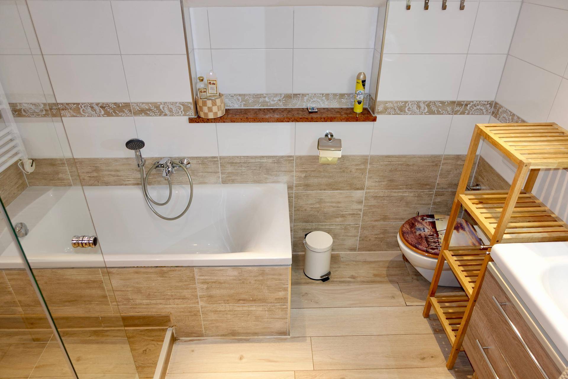 Modernes Badezimmer mit Badewanne, Dusche und hellen Fliesen.