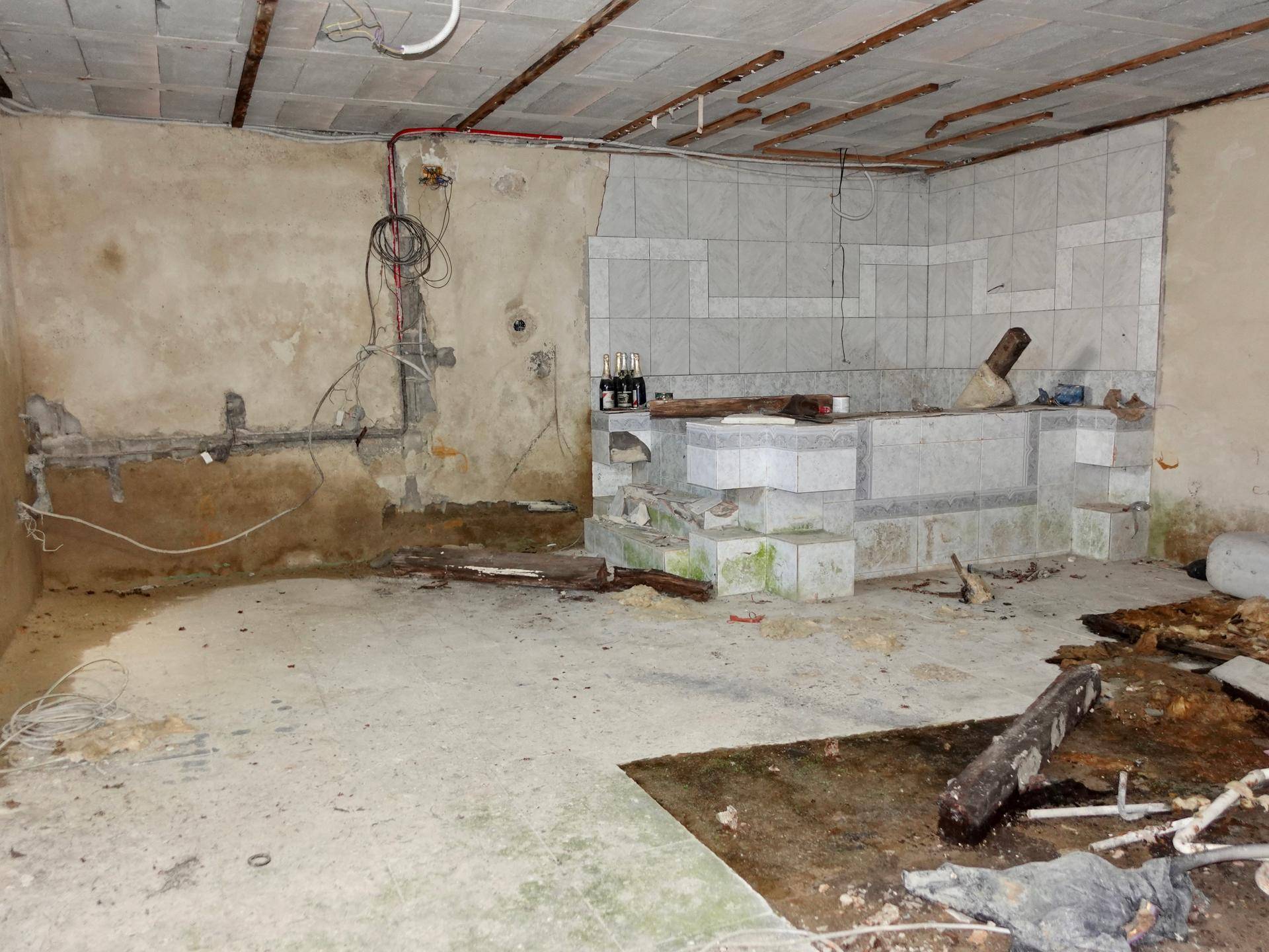 Unfertiger Kellerraum mit freiliegenden Leitungen und Betonboden, bereit für Ausbau.