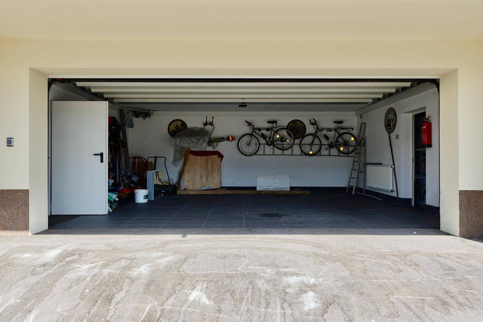 Geräumige Garage mit Fliesenboden und Platz für Fahrräder.