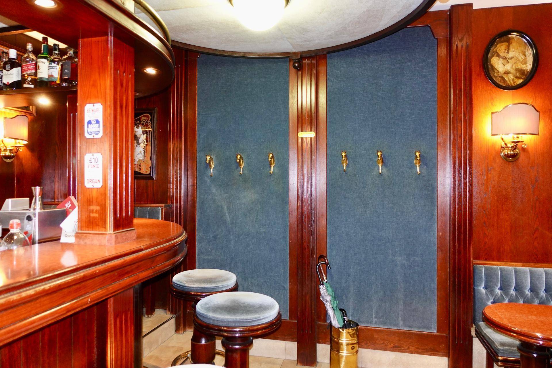 Ein weiterer Bereich der Bar mit Zapfhähnen an der Wand, Barhockern und gedämpfter Beleuchtung, die eine intime Stimmung erzeugt.
