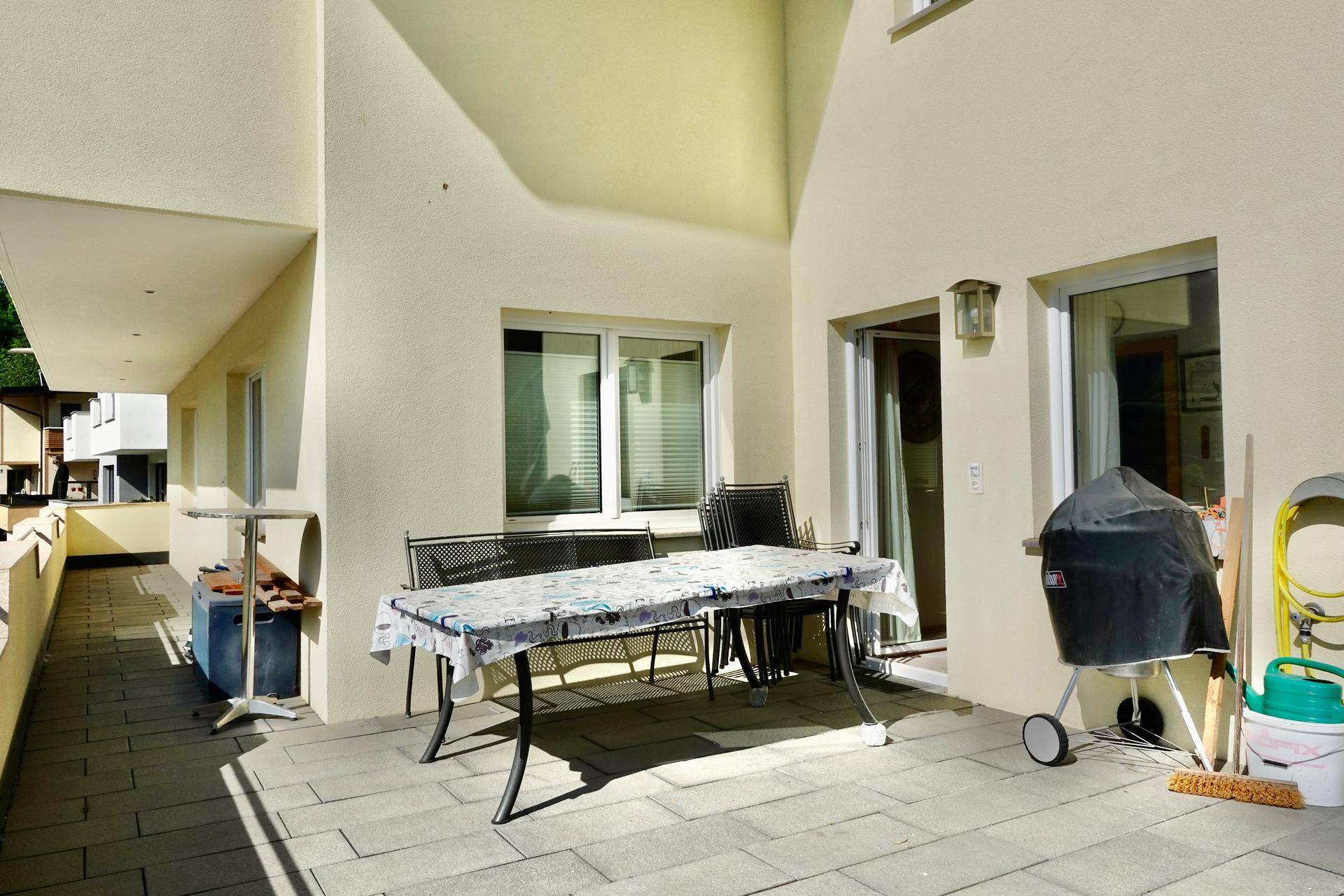 Geräumige Terrasse mit Esstisch, Grill und Blick auf die Umgebung.